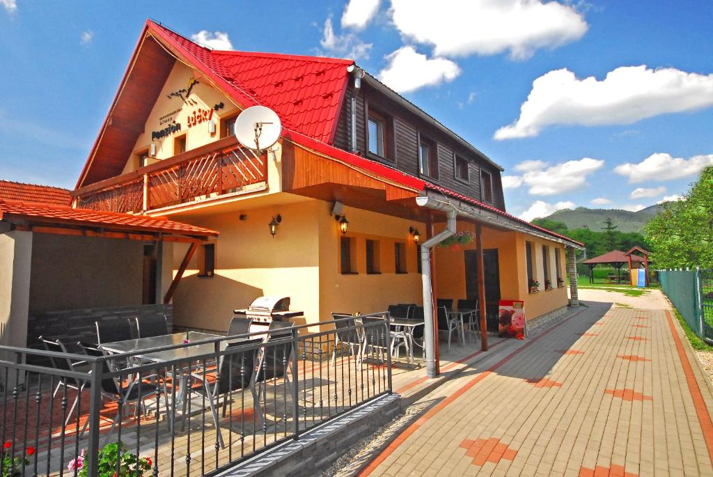 Casa con techo rojo y patio en Penzión Lúčky, en Lúčky