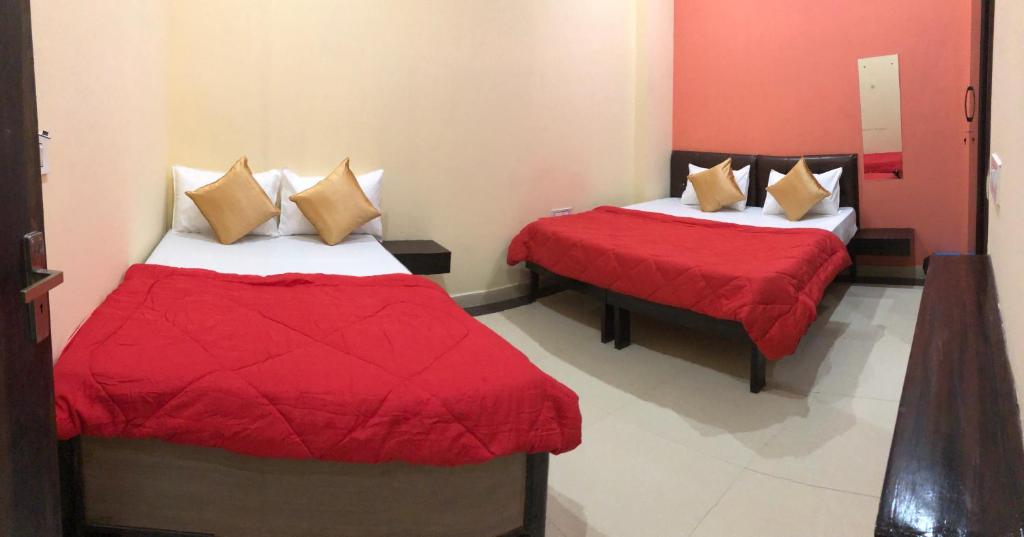 duas camas num quarto com vermelho e branco em The Taj Homes em Agra