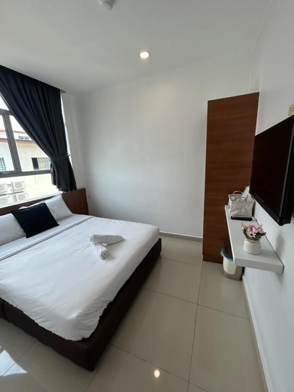 um quarto com uma cama grande e uma televisão em Pets and Family Guesthouse Kota Laksamana, Melaka em Malaca