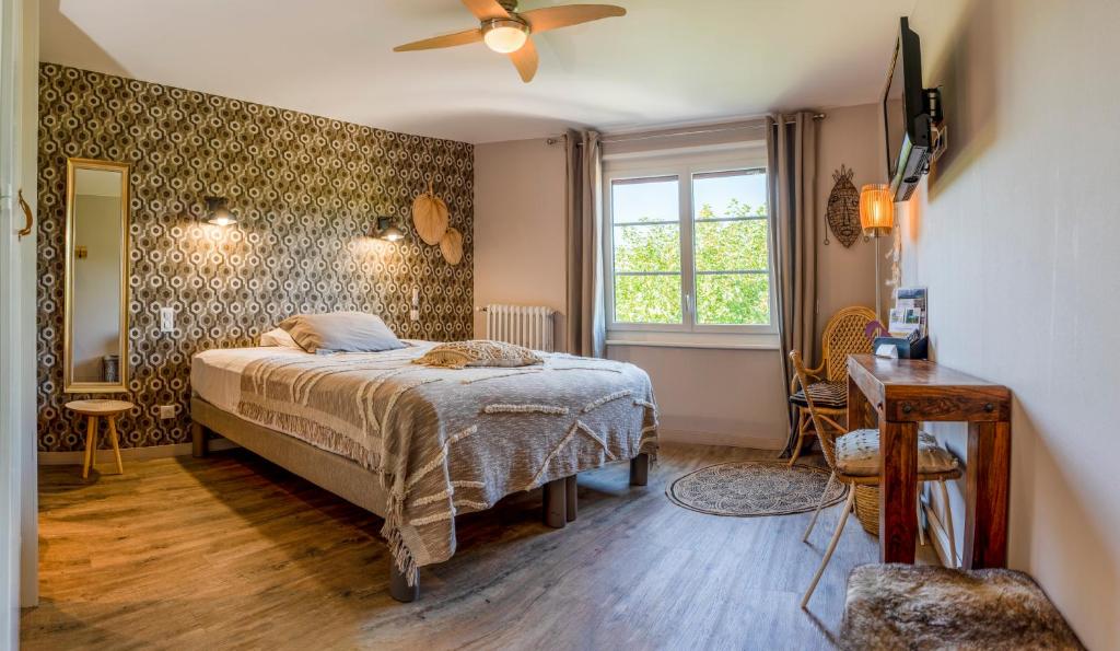 Schlafzimmer mit einem Bett und einem Deckenventilator in der Unterkunft Hotel-Restaurant Le Sorgia in Bellegarde-sur-Valserine