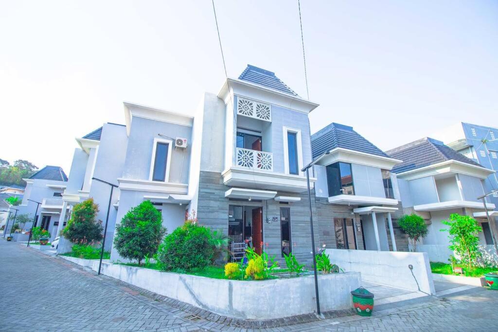 ein großes weißes Haus auf der Straßenseite in der Unterkunft Harsari Syariah with Karaoke and Balcony in Batu