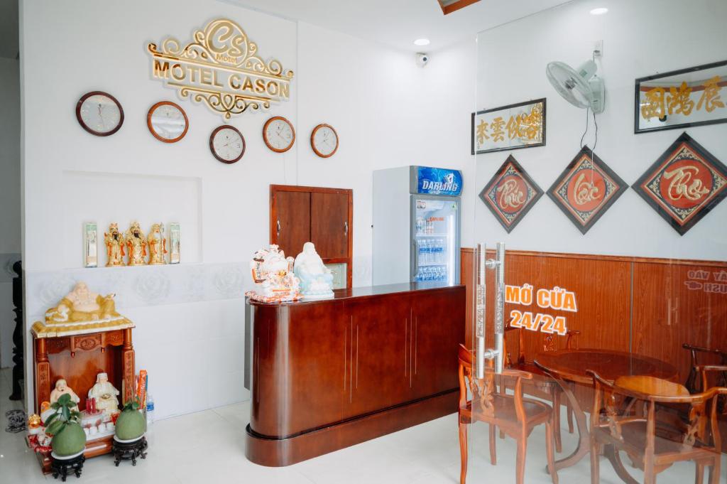 a restaurant with a table and chairs and clocks on the wall at MOTEL CASON in Chau Doc