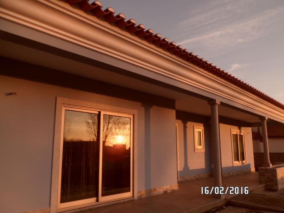 ein Haus mit einem Fenster mit Blick auf den Sonnenuntergang in der Unterkunft Maison proche de la mer in Murtosa