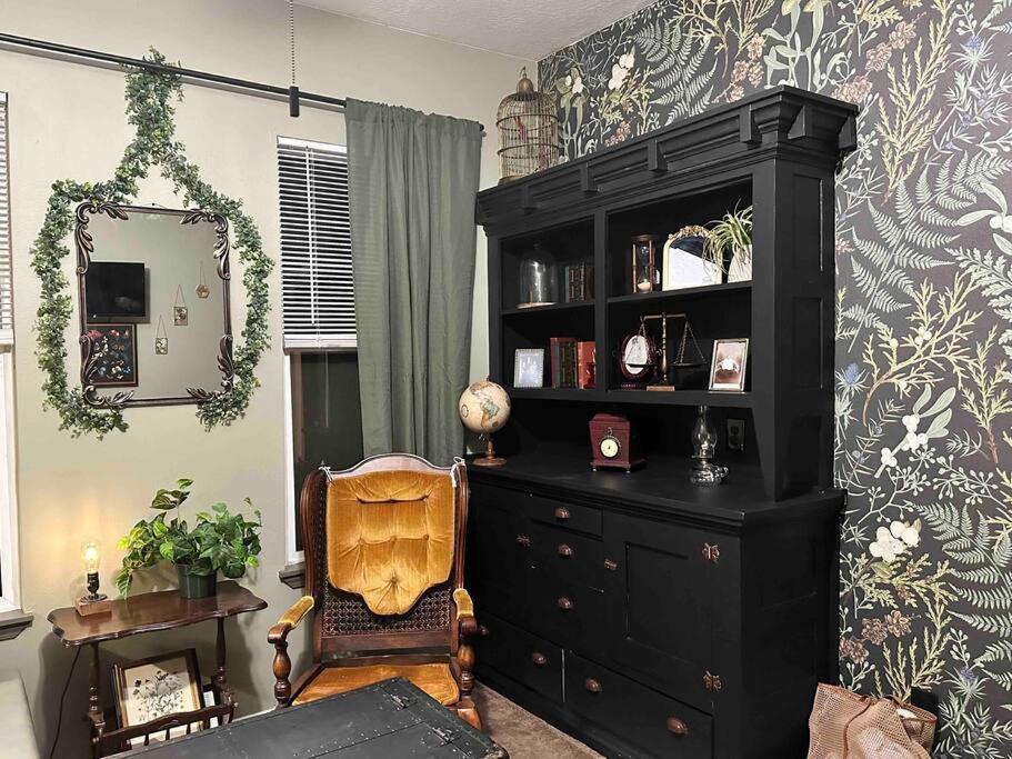 a living room with a black cabinet and a chair at Mr. McGregor’s Garden in Salem