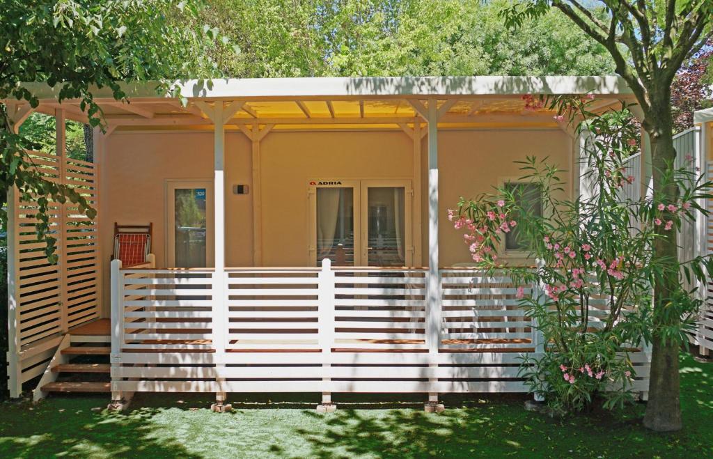 a house with a white fence in front of it at Portofelice Camping Village in Eraclea Mare