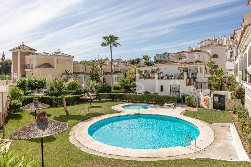 an image of a swimming pool in a yard with buildings at Bonito piso a 300m de la playa Nerja in Nerja