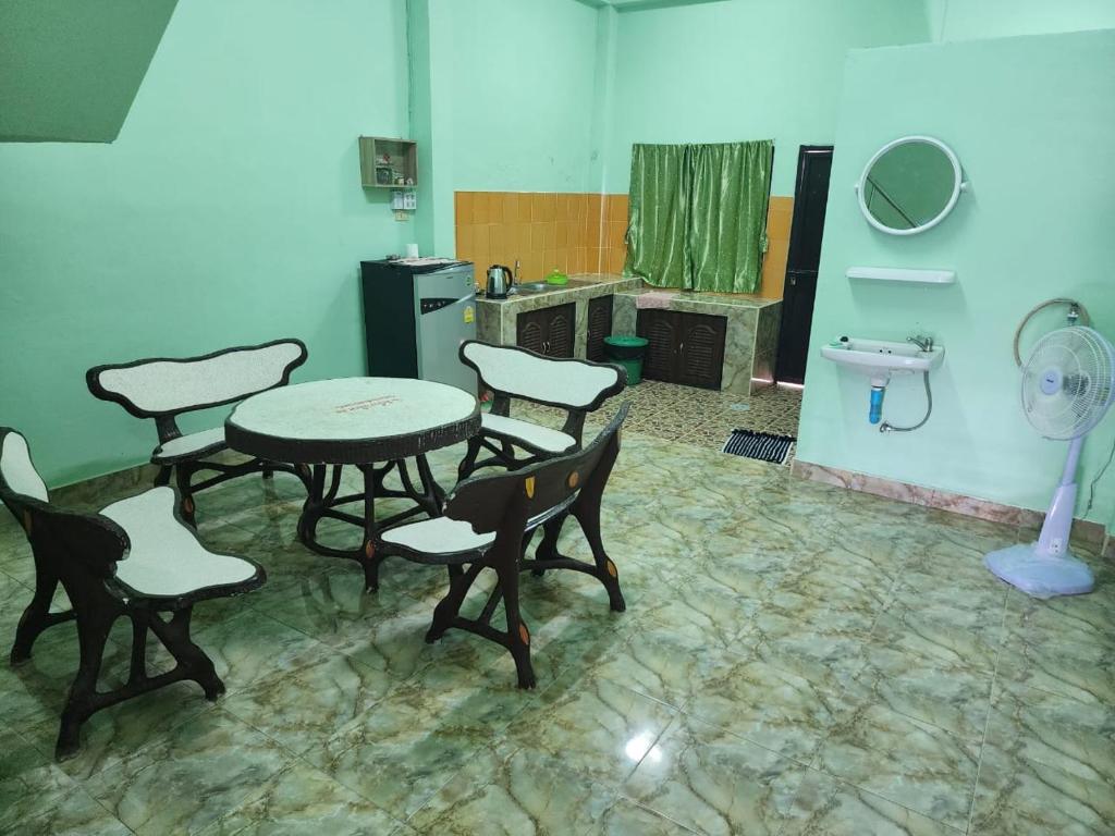 Habitación con mesa, sillas y lavabo. en SaamSaao HomeStay Betong สามสาวโฮมสเตย์เบตง 4 Bedroom House for Rent en Betong