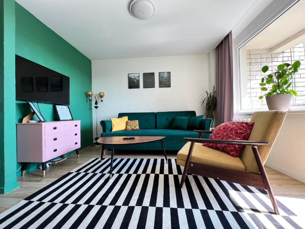 a living room with a blue couch and a table at Forrest Visaginas - Studio apartment in Visaginas