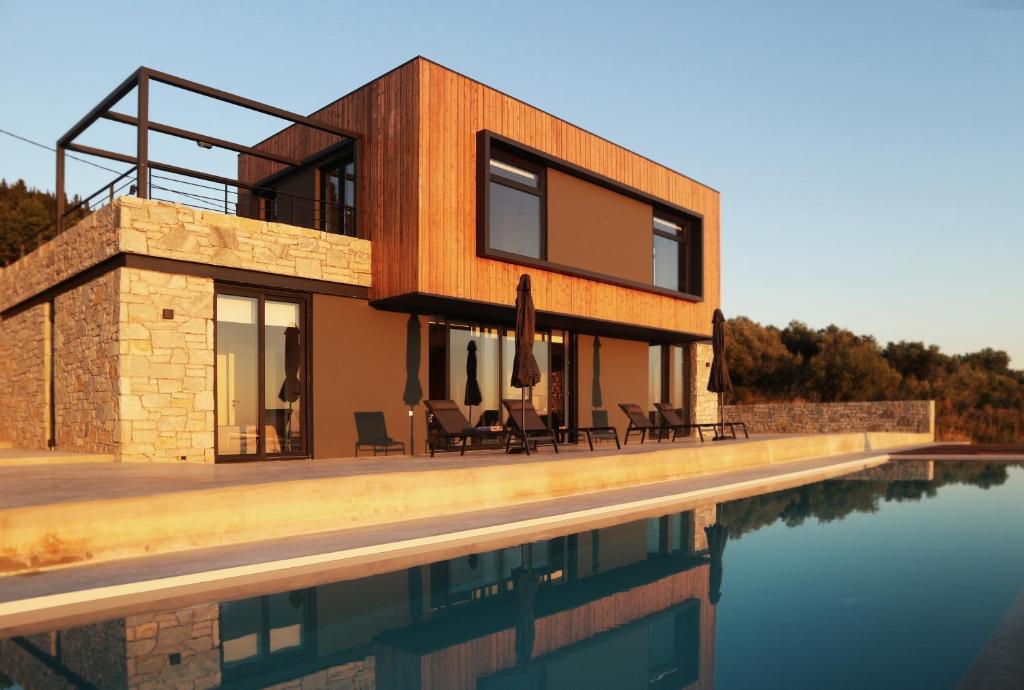 a house with a pool in front of it at Heterotopia Villas in Chortáta