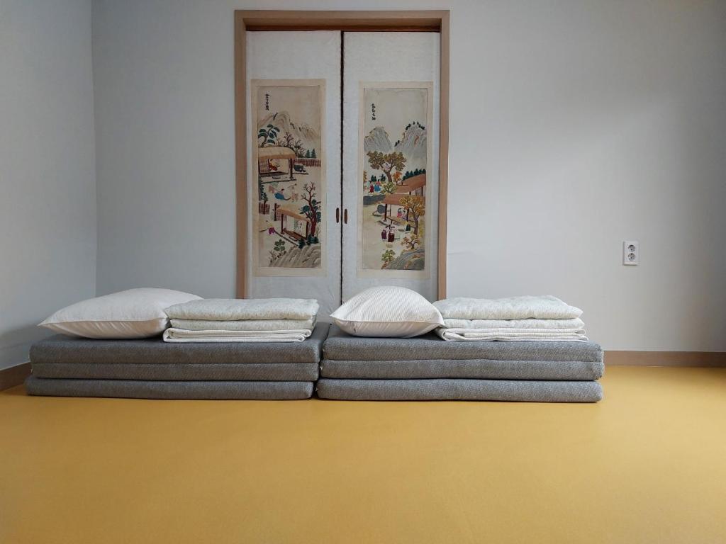 two pillows sitting on a bed in a room at Leedo Hanok in Seoul