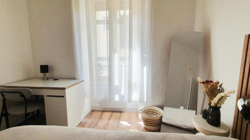 a bedroom with a bed and a desk and a window at Appartement au calme T3 RDC - Quartier de France in Vichy