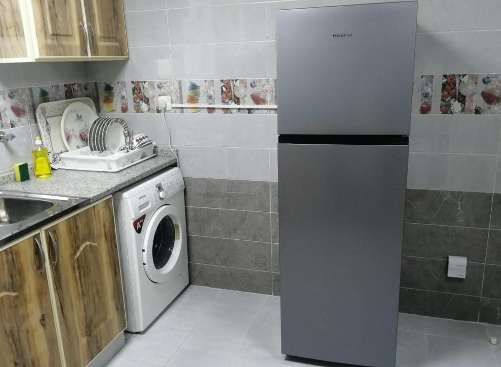 a kitchen with a washing machine and a sink at Al Rawda Apartments -Ajman in Ajman 