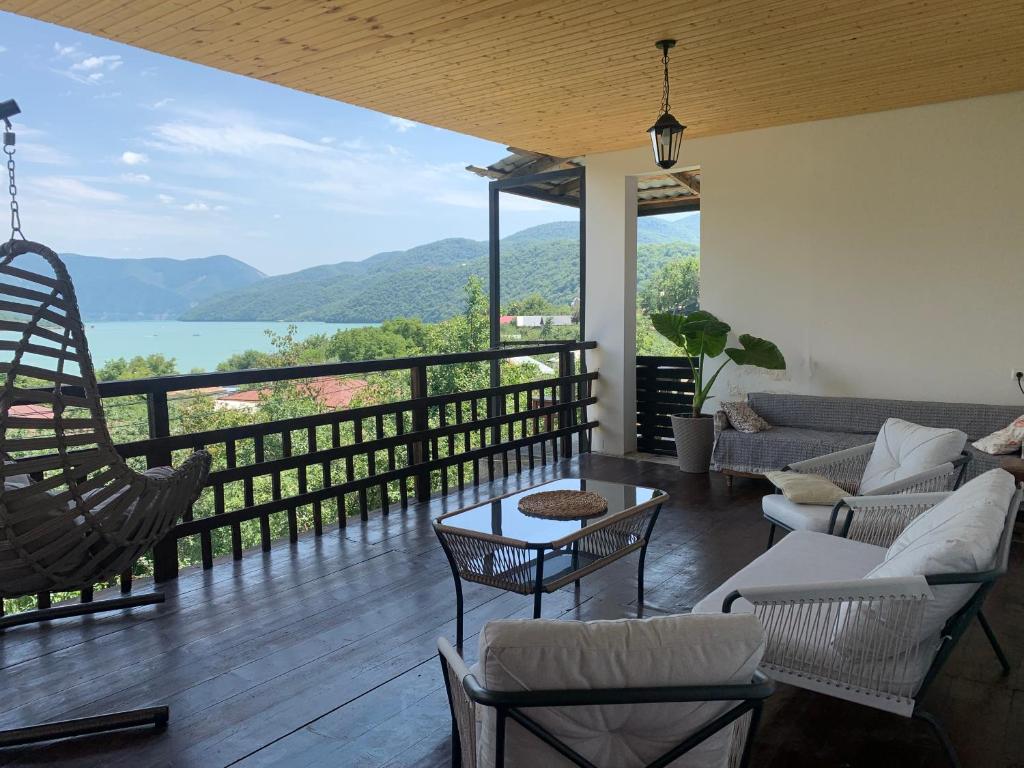 a living room with a balcony with a view of the water at Panorama ananuri guest house in Ananuri