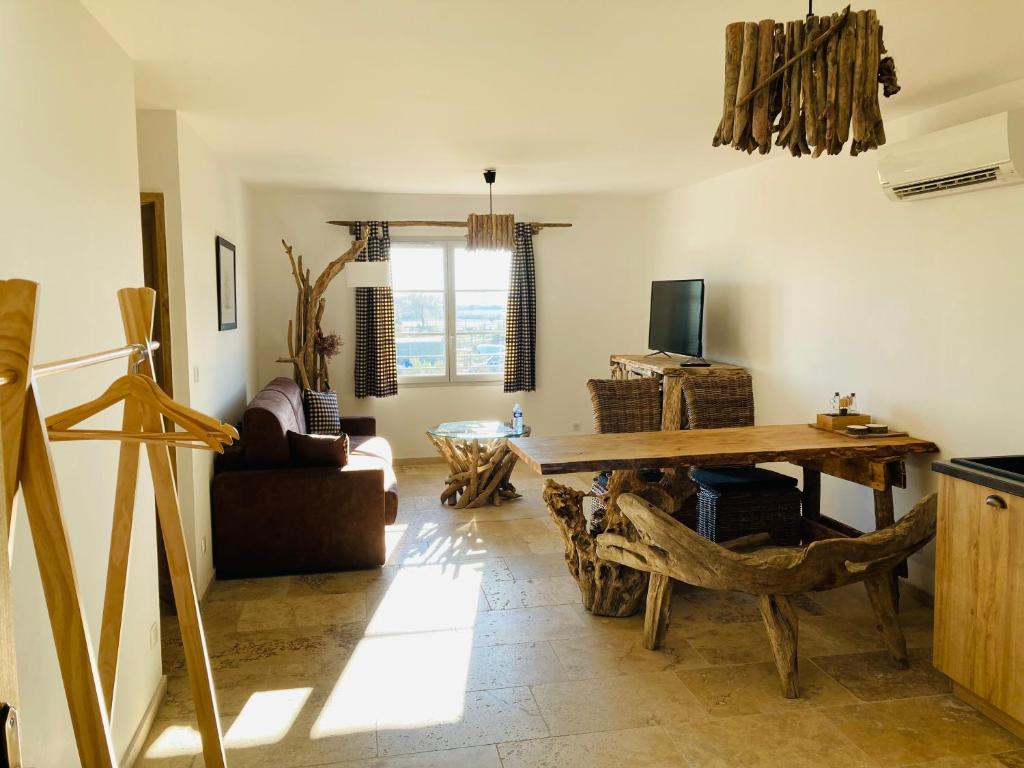 a living room with a wooden table and a couch at Manade des Baumelles in Saintes-Maries-de-la-Mer