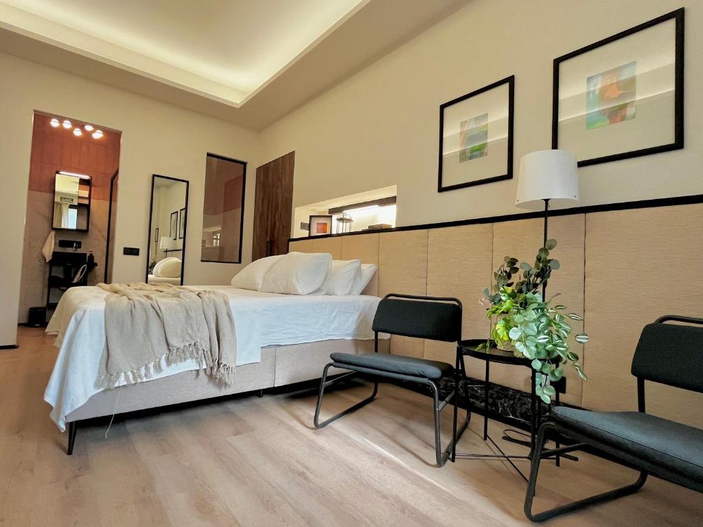 a bedroom with a white bed and two chairs at Retiro Studio in Madrid