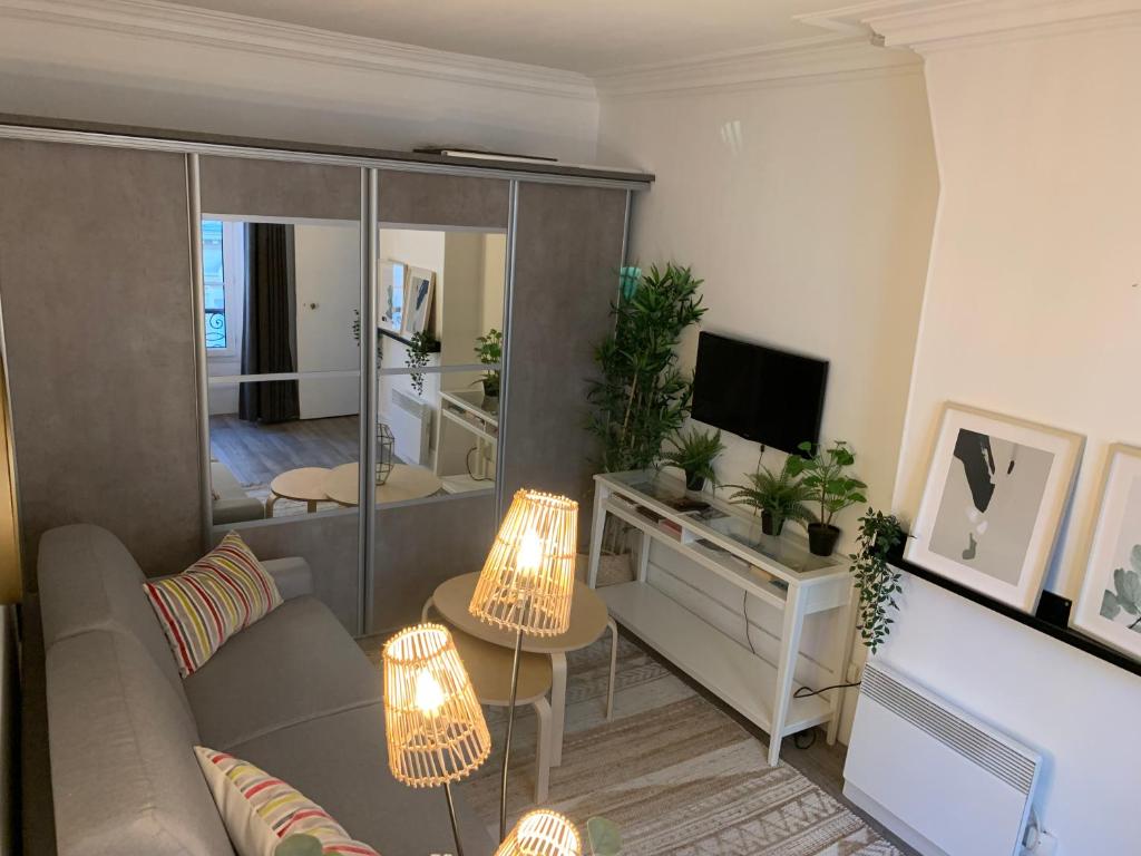 un salon avec un canapé et une télévision dans l'établissement Studio moderne au cœur de Paris Batignolles, à Paris