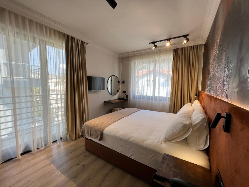 a bedroom with a large bed and large windows at Oji Hotel in Alanya