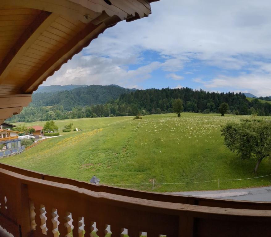 a view from the balcony of a house with a green field at Schroider in Kössen