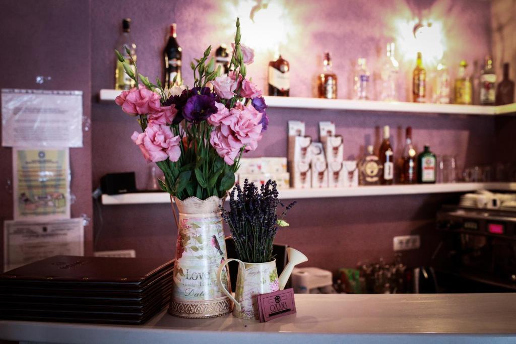 a vase of flowers sitting on a table in a bar at Pensiunea Oxana in Lipova