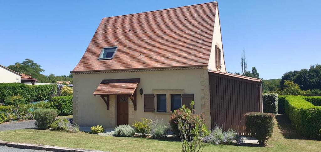 a small house with a brown roof at Maison Rose heerlijk ontspannen in luxe in Castelnaud La Chapelle