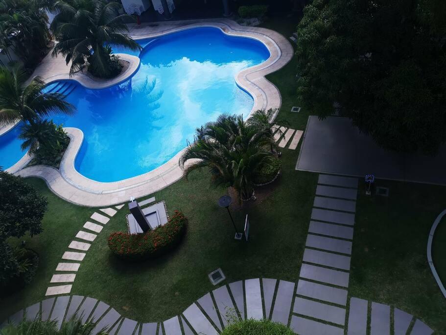 an overhead view of a large swimming pool with palm trees at Lindo DPTO en Condominio Cama KING in Santa Cruz de la Sierra