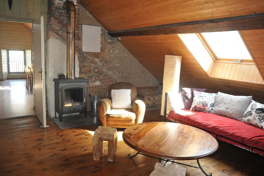 - un salon avec un canapé rouge et un poêle à bois dans l'établissement Grand appartement au centre du village minimum 2 nuits, à Autrans