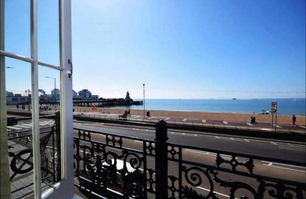 uma varanda com vista para a praia e para o oceano em Private Room BeachFront Apartment em Portsmouth