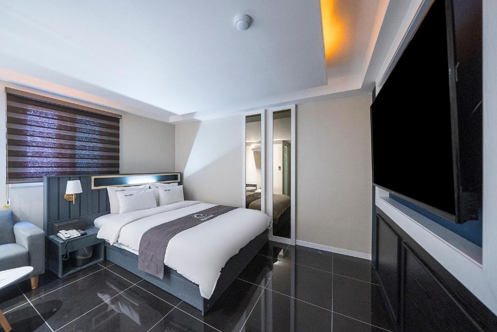 a bedroom with a large bed and a flat screen tv at Hotel Duruwa Main Building in Incheon