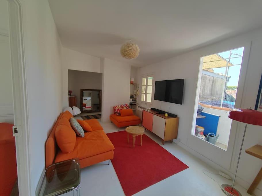 un soggiorno con divano arancione e tappeto rosso di Superbe T3 terrasse avec vue Centre historique a Montpellier