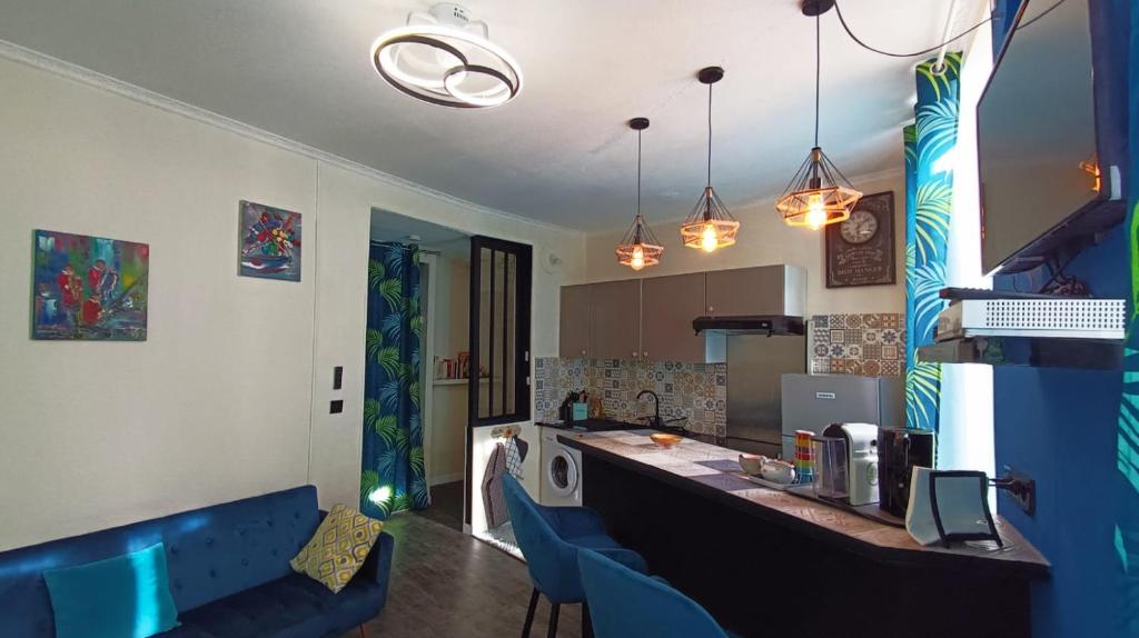 une cuisine avec un comptoir et des chaises bleues dans une pièce dans l'établissement LA PERLE DE LA PLAINE, à Marseille