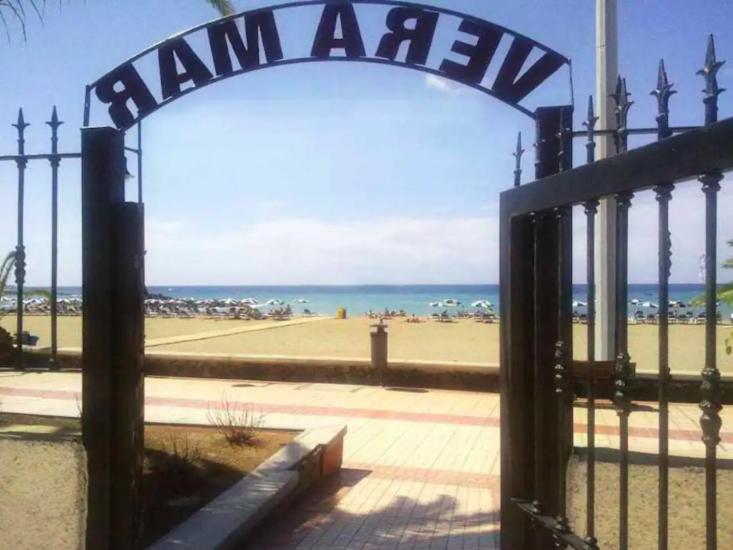 a gate with a sign that reads jam activ in front of the beach at Vera Mar 8A Primera linea con Piscina y Parking in Arona