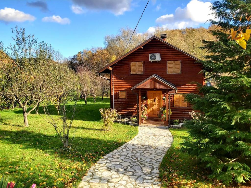 a log cabin with a pathway leading to the front door at Holiday House Bella in Bihać