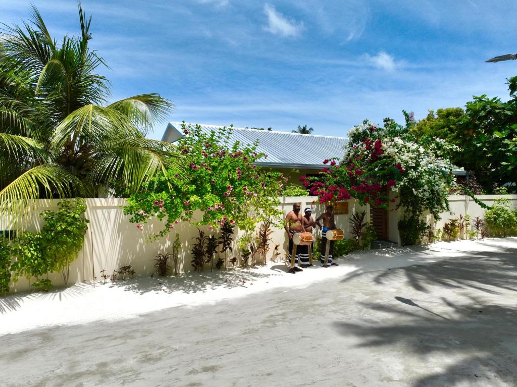 two people sitting in front of a house at Balma Beach Inn in Faafu