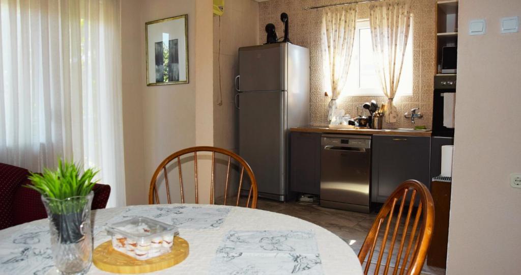 y cocina con mesa, sillas y nevera. en MANEVI Apartment, en Strumica