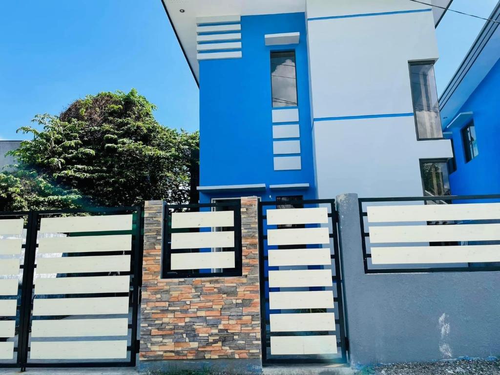 a blue and white house with a white fence at Marc louie estiaga home for rent in Iloilo City