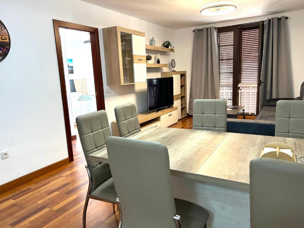 ein Wohnzimmer mit einem großen Holztisch und Stühlen in der Unterkunft Apartamento Lancelot in Arrecife
