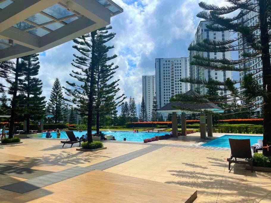 un complejo con piscina, árboles y un edificio en Scandinavian Room at Wind Residences en Tagaytay