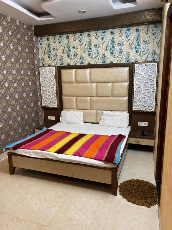 um quarto com uma cama com um cobertor colorido em HOTEL ROBIN em Amritsar