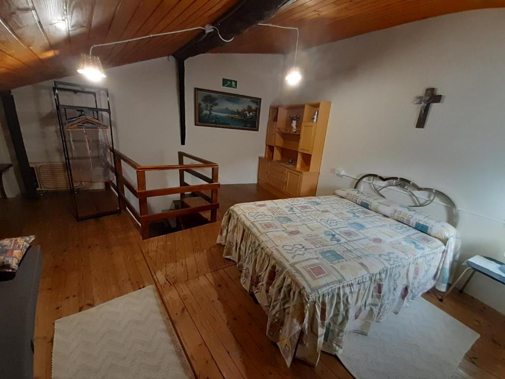 1 dormitorio con 1 cama y suelo de madera en Casa de tía Patricia, en Montemayor del Río