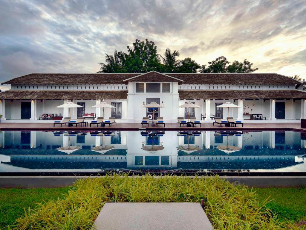 une maison avec une piscine en face de celle-ci dans l'établissement Sofitel Luang Prabang, à Luang Prabang