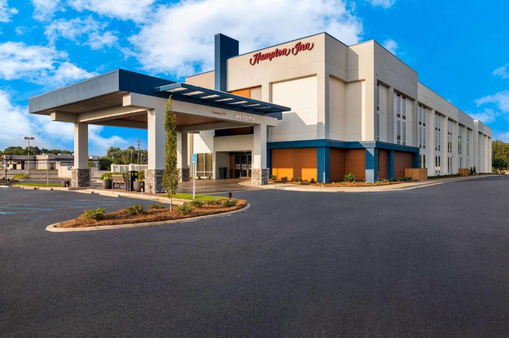 un edificio con un cartel de aceite mobil en un estacionamiento en Hampton Inn Gadsden, en Gadsden