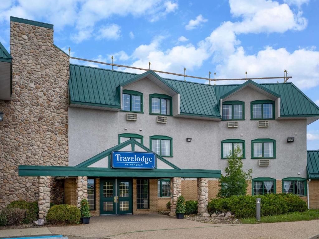 a hotel with a sign on the front of it at Travelodge by Wyndham Lacombe in Lacombe