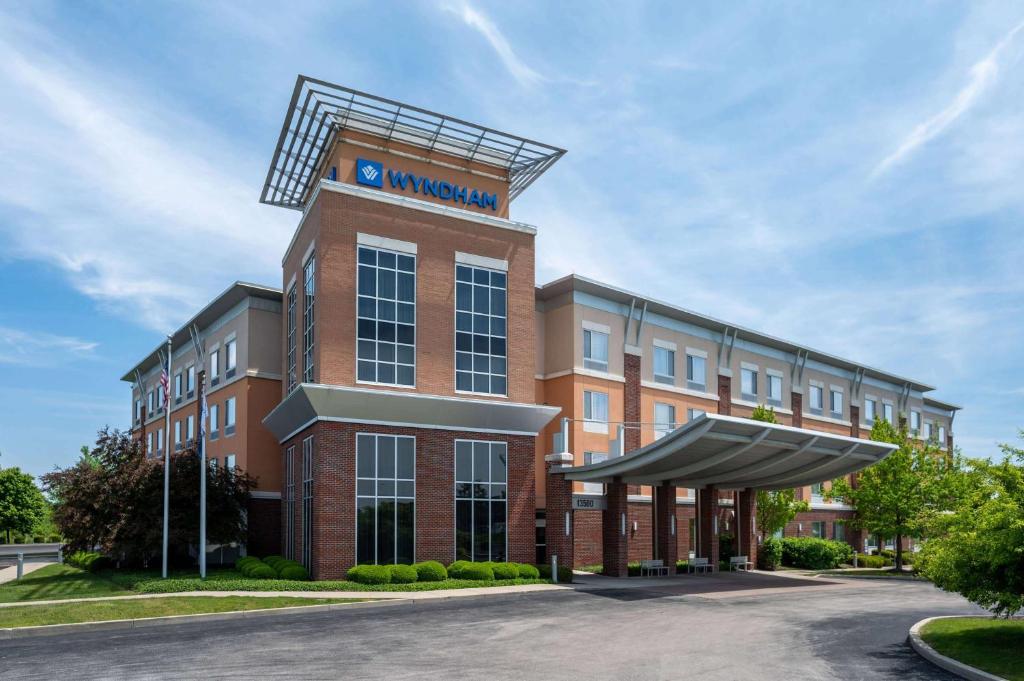 a large red brick building with a sign on it at Wyndham Noblesville in Noblesville