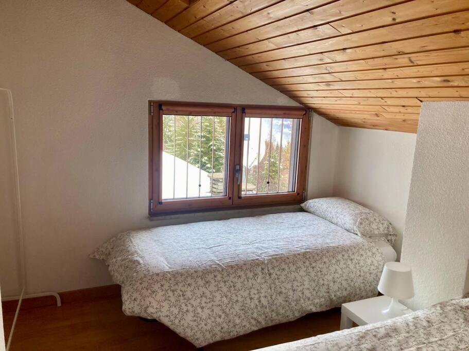 a bedroom with two beds and a window at Appartamento sulle piste Folgarida in Folgarida