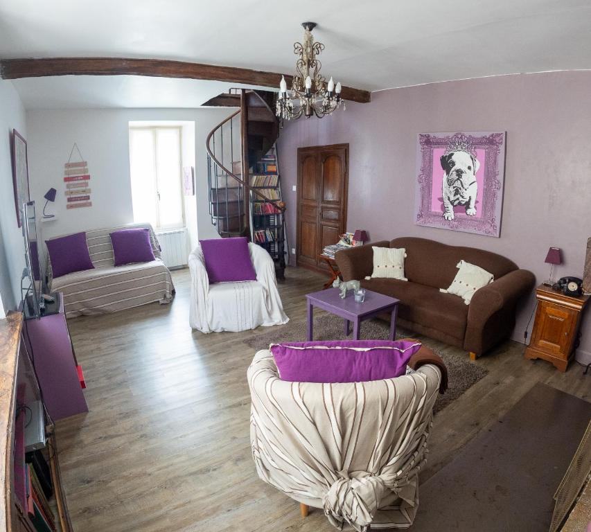 a living room with purple and white furniture at La p'tite maison 