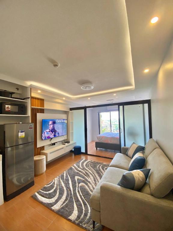 a living room with a couch and a flat screen tv at Staycation Condo at One Oasis CDO in Cagayan de Oro