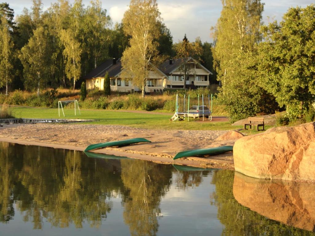 una piscina de agua con una casa en el fondo en Hjortö Stugor & Stockhus en Ödkarby