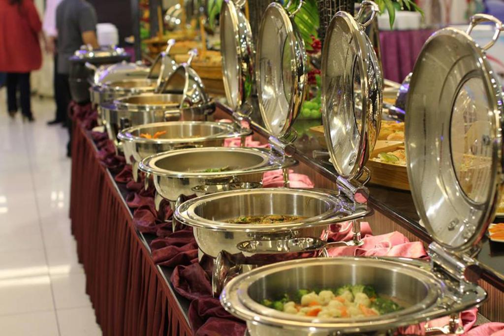 a row of plates of food on a buffet at Badi'ah Hotel in Bandar Seri Begawan