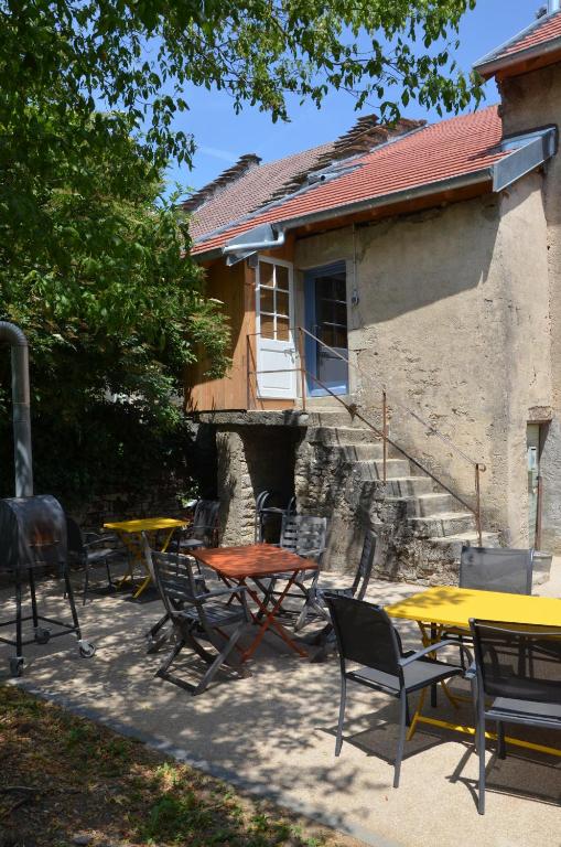 a group of tables and chairs in front of a house at les gites du passage: le nid in Passenans