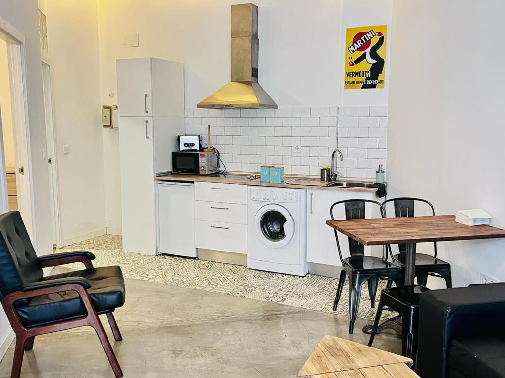 une cuisine avec un lave-linge et une table avec des chaises dans l'établissement Moderno apartamento 2habitaciones Avda América, à Madrid